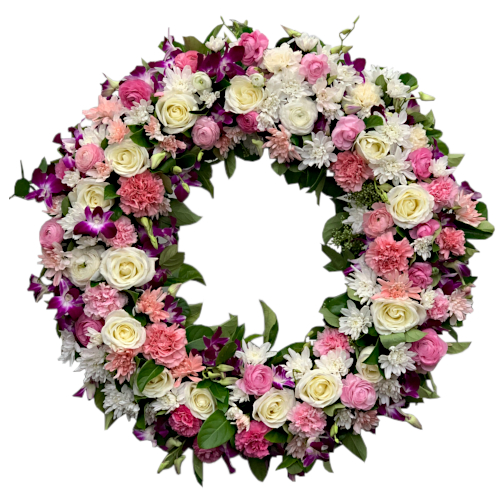 Like butterflies, purple dendrobium orchids flutter amongst a peachy garden of roses, chrysanthemums, carnations and buttercup flowers arranged in a ring wreath. Butterflies carry a symbol of transformation and transcendence.