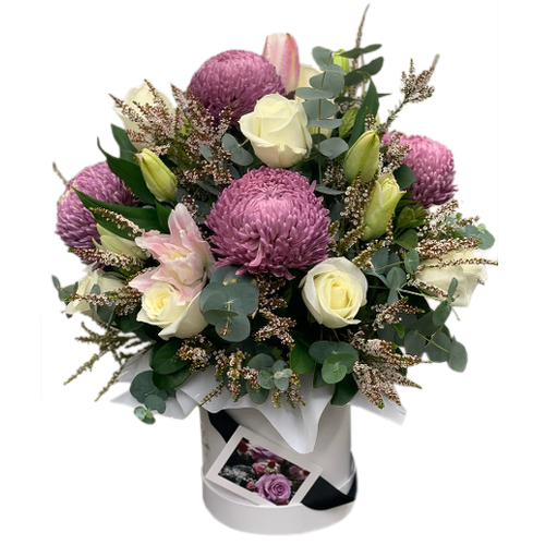 Vibrant chrysanthemum bulbs stand big and bright amongst white stargazer lilies and fresh cut roses. These prominent flowers are complimented by filler flowers of the same colour palate and dusty eucalyptus leaves to set a romantic and mysterious tone.